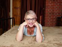 Mature blonde Lady X strips naked and toys her trimmed pussy on her bed - Photo #2