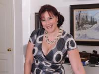 Mature lady strips off her clothing to pose nude in her living room - Photo #3