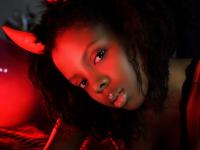 Pretty black girl Sukki T unveils her hairy pussy during a striptease on a bed - Photo #1