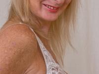 Lusty mature blonde with saggy tits undressing and fingering her twat - Photo #5