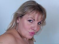 Older blonde woman blows a kiss after stripping to her jewelry - Photo #16