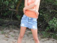 Sexy teen with short hair exposes her tiny tits and bald pussy on a beach - Photo #1