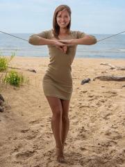 Tall teen Mina hangs wet clothes to dry while posing nude on a beach