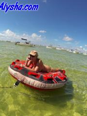 Big titted amateur lounges on an air mattress while naked in a ball cap