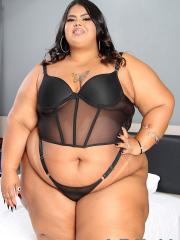 Ebony SSBBW discards black lingerie to get naked on top of a bed