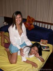 Young Asian girls undress before lesbian sex commences on a bed