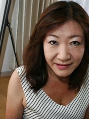 Asian granny Michiko Okawa undressing and exposing her hairy twat in close up