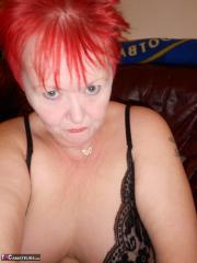 Mature redhead fatty Valgasmic Exposed exposes her bald pussy in fishnets