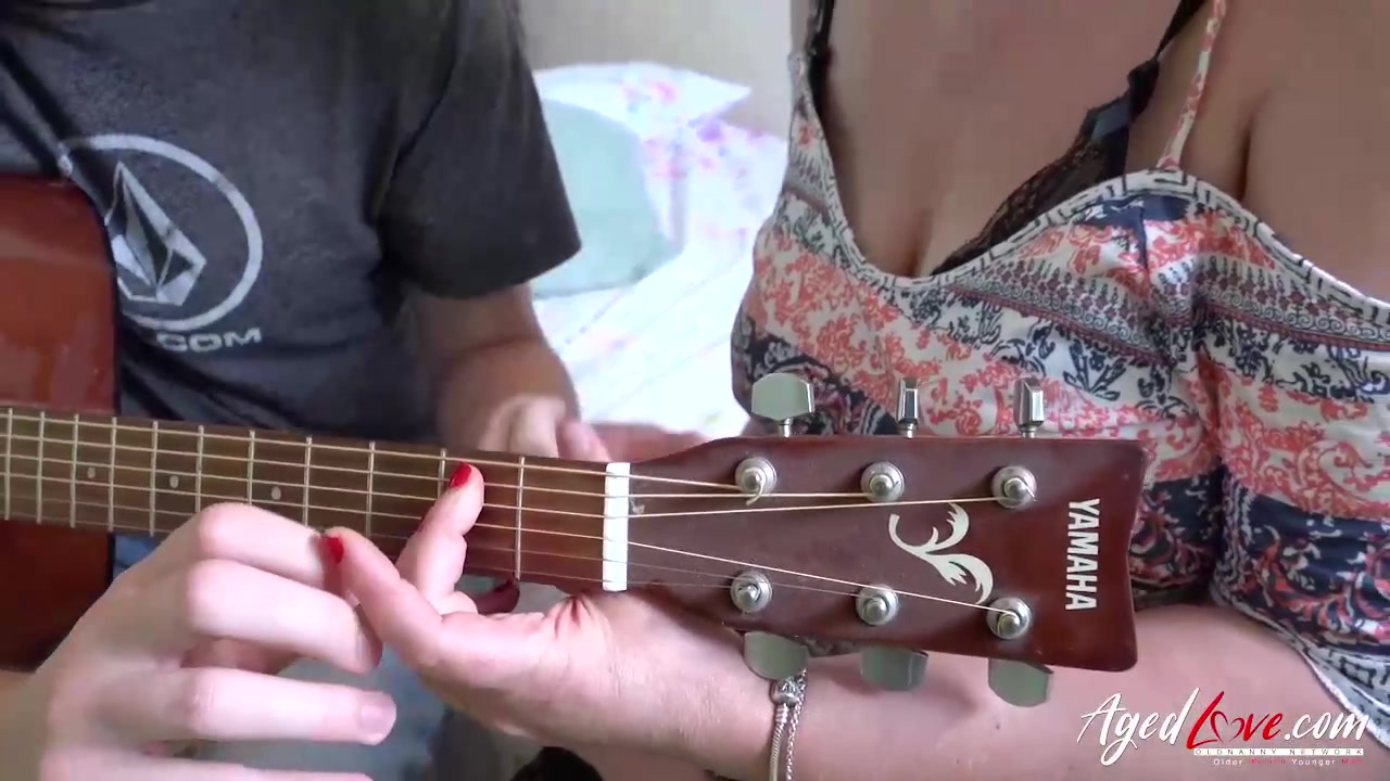 Mature lady is giving a blowjob to a younger guy after they were having a guitar lesson